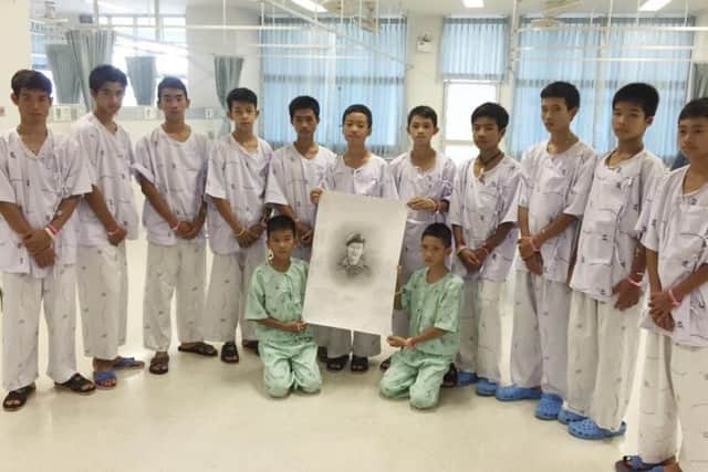 The rescued soccer team members pose with a sketch of the Thai Navy SEAL diver who died while trying to rescue them