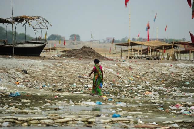 A woman walks among vast amounts of waste by the Ganges - one of the rivers which Ocean Polymers hopes to start clearing. Picture: Getty