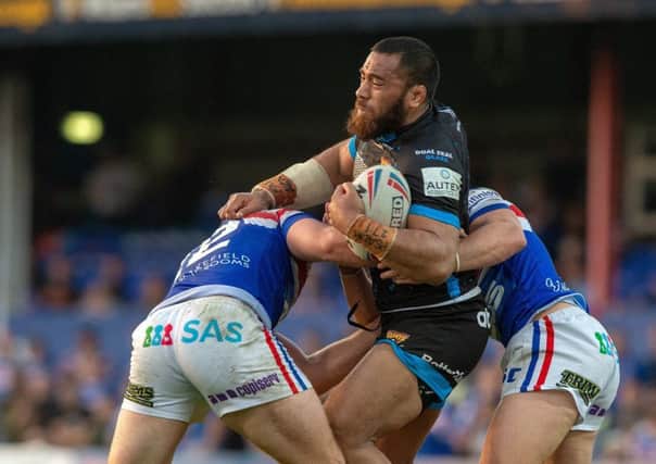Huddersfield's Suaia Matagi is held by Wakefield's Jacob Miller and George King. Picture Bruce Rollinson