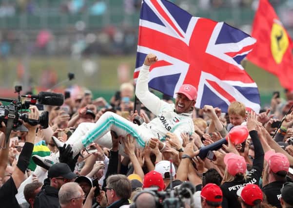 Mercedes driver Lewis Hamilton celebrates winning the British Grand Prix at Silverstone.