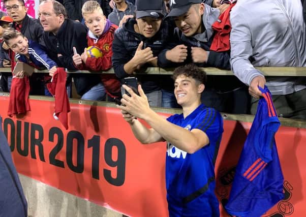 Manchester United's Daniel James poses for a selfie with fans.