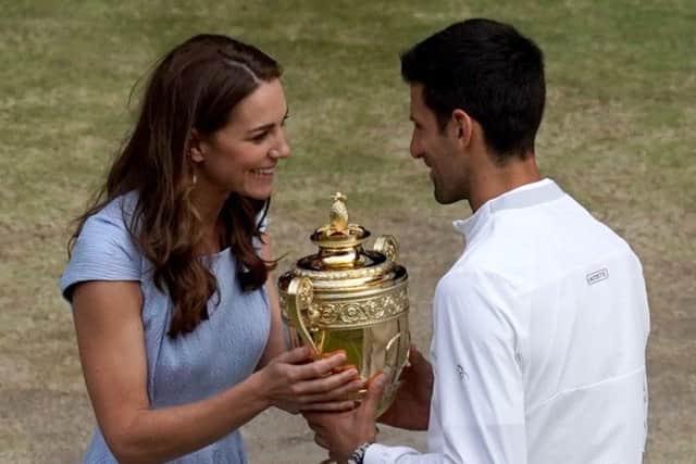 Novak Djokovic is presented with the winners trophy by the Duchess of Cambridge after beating Roger Federer. Picture: Will Oliver/PA