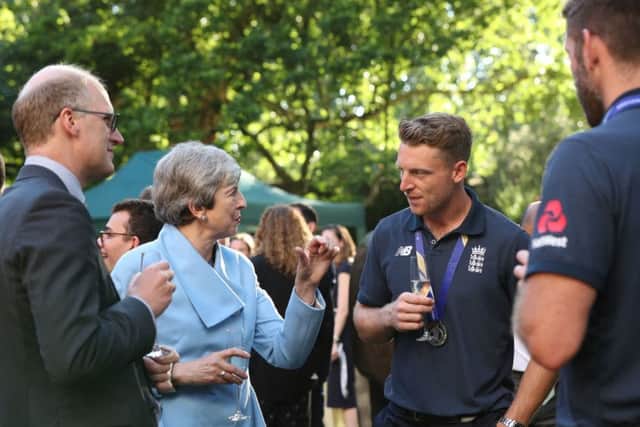 Theresa May discusses tactics with wicketkeeper-batsman Jos Buttler.
