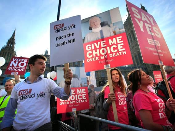 Protesters outside the Houses of Parliament in London as MPs debate and vote on the Assisted Dying Bill in 2015. Jonathan Brady/PA Wire.
