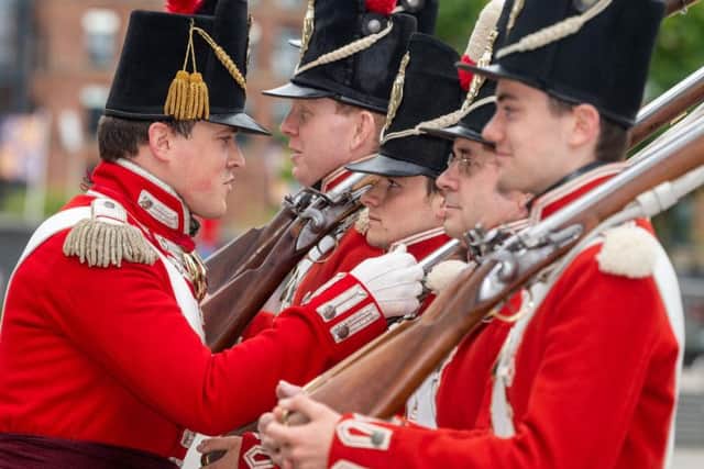 Royal Armouries interpreter Sam Love inspects his members of the 33rd Regiment of Foot. Picture by James Hardisty.