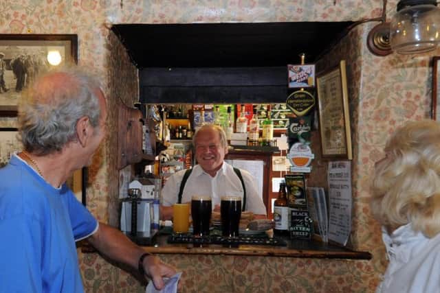 Barman John Hunt at the serving hatch
