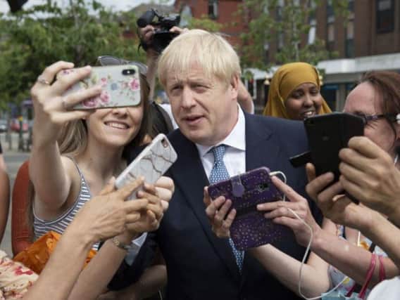 Prime Minister Boris Johnson taking selfies with supporters.