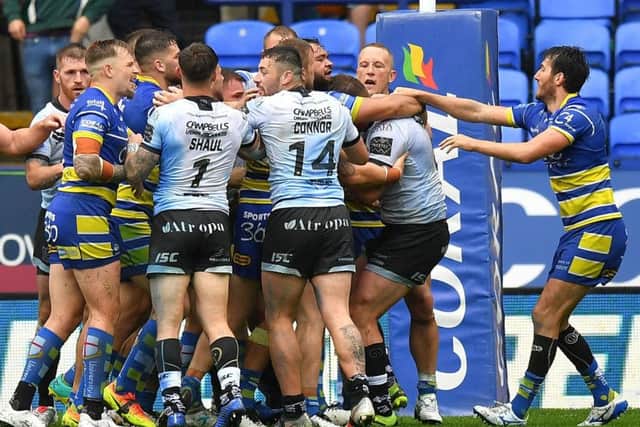 Getting to grips: Tempers begin to flare between Hull FC and Warrington Wolves players.