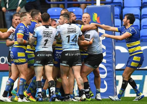 Getting to grips: Tempers begin to flare between Hull FC and Warrington Wolves players.