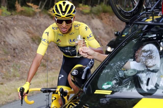 CHEERS! Colombia's Egan Bernal wearing the overall leader's yellow jersey drinks champagne at the car of his team director. Picture: AP/Thibault Camus