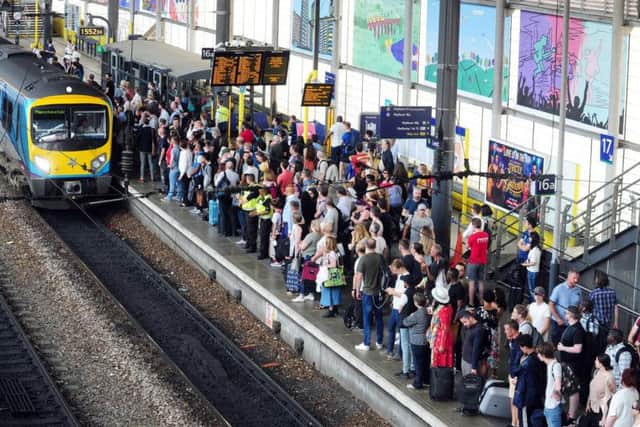Commuters wait for a train on a crowded platform at Leeds station.