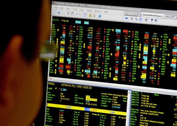 Office worker looks at a screen showing trading on the FTSE 100 index. Photo credit should read: PA Wire