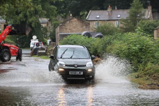 A car being driven through flood water. Photo: Danny Lawson/PA Wire