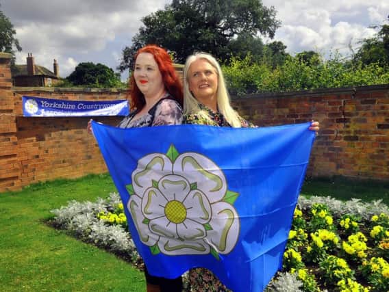Rebecca Hoggarth-Hall (left) and Angela Kay from the Yorkshire Countrywomen Association wrapped in the Yorkshire flag at their gathering in the Walled Gardens at Temple Newsam, Leeds on Yorkshire Day. Picture by Gary Longbottom.