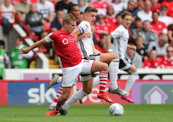 Barnsley's Luke Thomas (left) and Fulham's Tom Cairney (right) battle for the ball (Picture: PA)