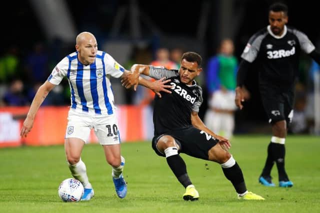 Huddersfield Town's Aaron Mooy (left) and Derby County's Mason Bennett battle for the ball. Picture: Martin Rickett/PA
