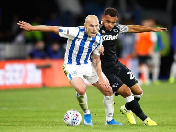 On the ball: Huddersfield Town's Aaron Mooy (left) and Derby County's Mason Bennett battle for possession.