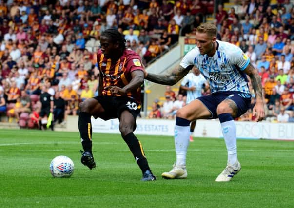 Clayton Donaldson, of Bradford City, plays the ball infront of George Taft, Cambridge United. (Picture: James Hardisty)