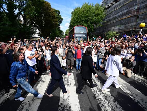 Beatles impersonators recreate the iconic 'Abbey Road' photograph made 50 years ago today, on August 8, 2019 in London, England. 50 years ago today, John Lennon, Paul McCartney, George Harrison and Ringo Starr held up traffic on the zebra crossing outside their recording studio in north London to get the cover shot for the album, Abbey Road. (Photo by Leon Neal/Getty Images)