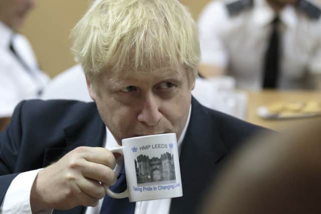 LEEDS, ENGLAND - AUGUST 13: UK Prime Minister Boris Johnson takes a drink from a prison mug as he talks with prison staff during a visit to Leeds prison on August 13, 2019 in Leeds, England. In an announcement on Sunday Johnson promised more prisons and stronger police powers in an effort to fight violent crime. (Photo by Jon Super - WPA Pool/Getty Images)