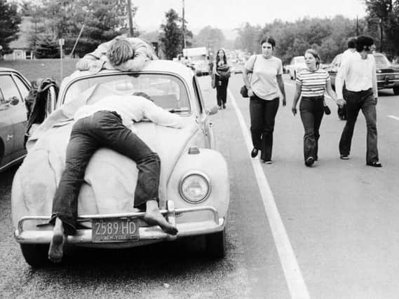 Two festival goers that found Woodstock too much lay passed out on a car bonnet. Picture: Getty Images