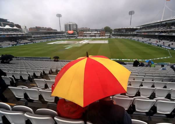 Fans shelter from the rain at Lord's.