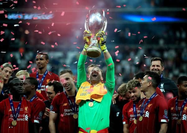 Liverpool's goalkeeper Adrian celebrates victory with the trophy.