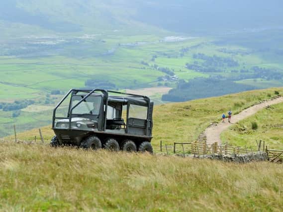 A ranger drives an ATV to the summit of Whernside