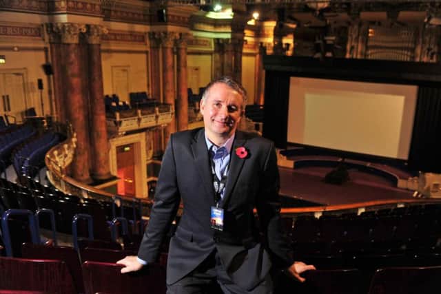 Leeds International Film Festival director Chris Fell in front of a huge movie screen within the impressive setting of Leeds Town Hall. Picture by Tony Johnson.