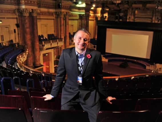 Leeds International Film Festival director Chris Fell in front of a huge movie screen within the impressive setting of Leeds Town Hall. Picture by Tony Johnson.