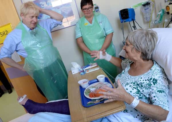 Prime Minister Boris Johnson serves food to Wenona Pappin, 70, during a visit to Torbay Hospital in Devon after he welcomed a review into hospital food following the deaths of six people due to a listeria outbreak. PRESS ASSOCIATION Photo. Picture date: Friday August 23, 2019. Great British Bake Off judge Prue Leith is to advise a Government review into hospital food launched by the Department of Health and Social Care on Friday, which will examine whether the number of hospitals catering in-house can be increased.
