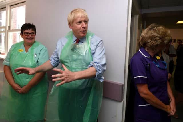 Prime Minister Boris Johnson speaks to staff during a visit to Torbay Hospital in Devon after he welcomed a review into hospital food following the deaths of six people due to a listeria outbreak.