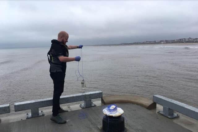 An Environment Agency officer recently taking a water sample off the harbour wall in Bridlington