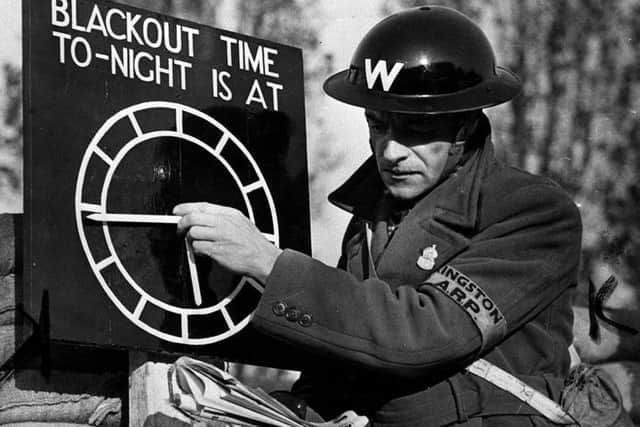 An air-raid warden sets a black-out time clock indicator in 1939. Photo: PA