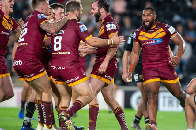 Huddersfield Giants players celebrate with Matt Frawley after his match-clinching try against Hull FC. (PIC: BRUCE ROLLINSON)