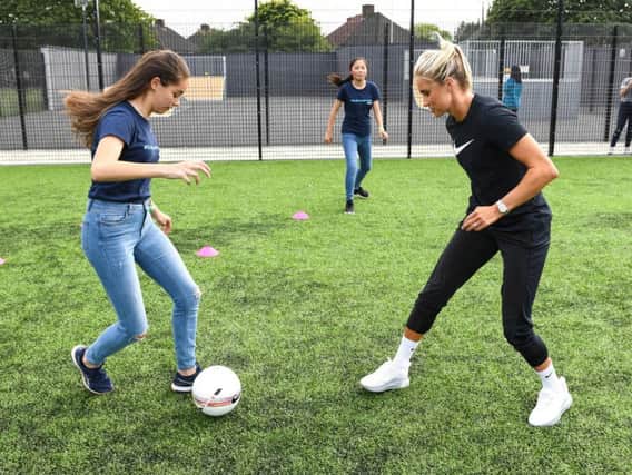 England football captain Steph Houghton with Fiona Eagleson (left) and Angela Lin, both aged 13, at an Always #EndPeriodPoverty event in Essex. Photo: Doug Peters/PA.