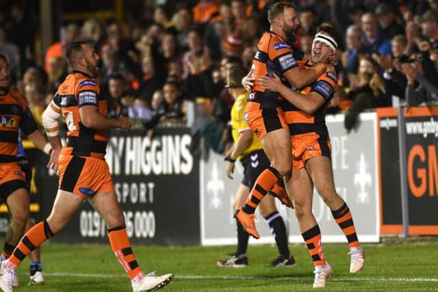 Castleford Tigers' Paul McShane leaps on Jake Trueman after his team-mate scores his hat-trick try against Hull FC. (PIC: JONATHAN GAWTHORPE)