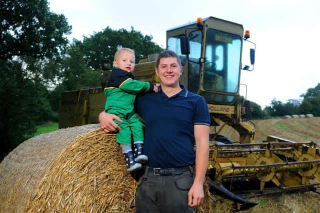 Sam Raynes with his son Matthew, aged two, at Carr Lane Farm near Penistone. Picture by Tony Johnson.