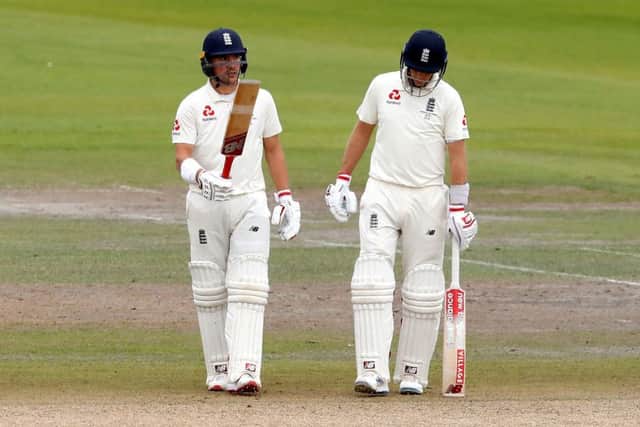 England's Rory Burns (left) celebrates reaching his half century at Emirates Old Trafford with captain Joe Root alongisde, right. Picture: Martin Rickett/PA