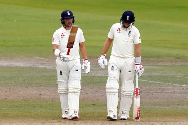 England's Rory Burns (left) celebrates reaching 50 at Old Trafford, with captain Joe Root alongside, right. Picture: Martin Rickett/PA