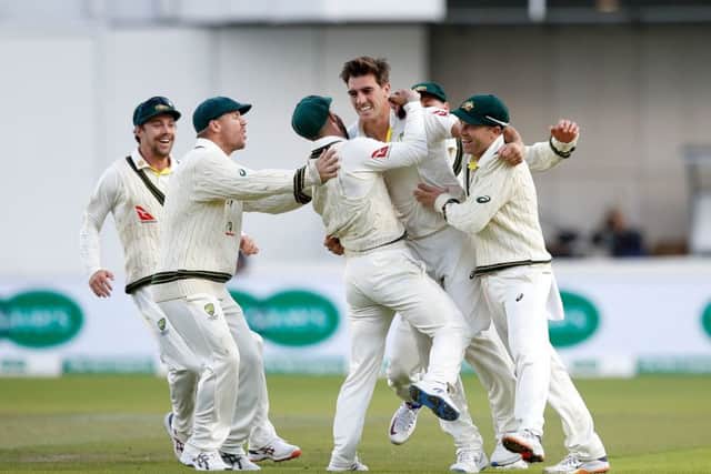 Australia's Pat Cummins (centre) celebrates with his team-mates after taking the wicket of England's Joe Root at Old Trafford. Picture: Martin Rickett