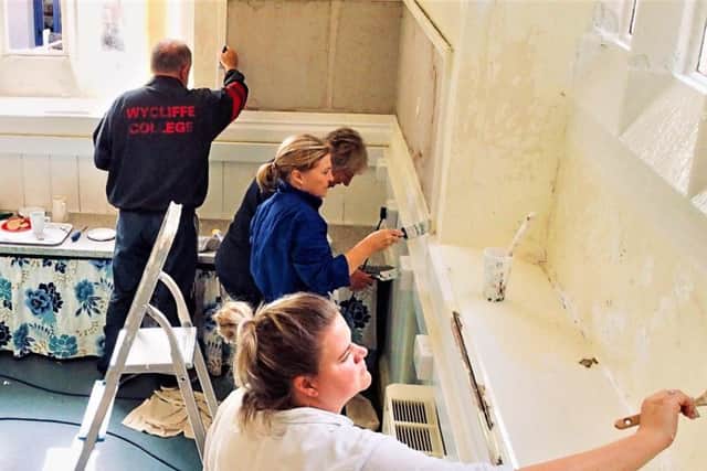 Governors and community volunteers painting classroom one at Clapham school in preparation for the new term, after it was saved from closure. Photo: Submit