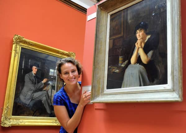 Helena Cox, curator of Beverley art gallery, looking at a painting by Frederick Elwell of his wife Mary. In the background is a self portrait of Elwell.