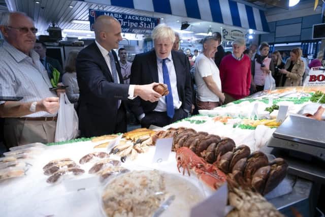 Boris Johnson discusses the price of fish at Doncaster Market with Northern Powerhouse Minister Jake Berry.