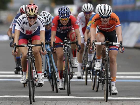 Elizabeth Armitstead, left, of Great Britain, passes Anna Van Der Breggen, right, of the Netherlands and Megan Guarnier, center, of the United States to the line to win the Women's Elite road circuit cycling race at the UCI Road World Championships in Richmond (AP Photo/Gerry Broome)