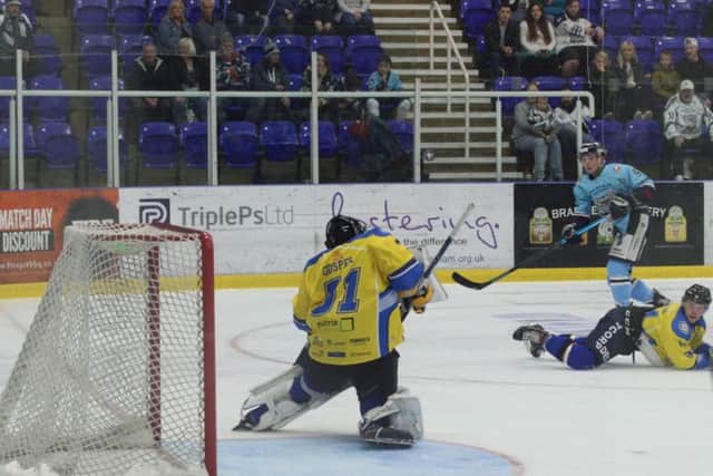 Cameron Brownley, far right, gets a shot in on Sam Gospel in the Leeds Chiefs' goal on Sunday at Ice Sheffield. Picture: Cerys Molloy.