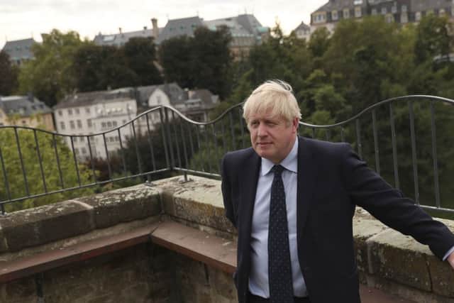 Prime Minister Boris Johnson poses for photographers on the balcony of the UK ambassadors residence prior to giving a statement to television after a meeting with Luxembourg's Prime Minister Xavier Bettel in Luxembourg.