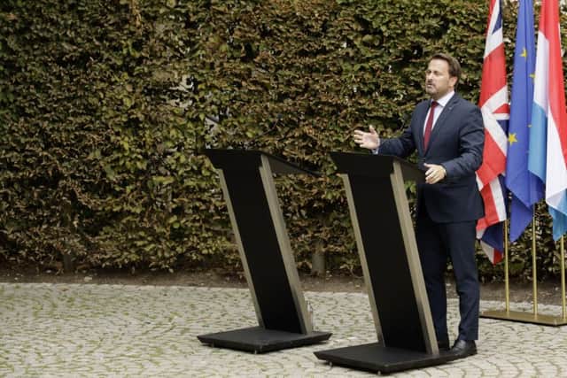 Luxembourg's Prime Minister Xavier Bettel, right, addresses a media conference next to an empty lectern intended for British Prime Minister Boris Johnson after a meeting at the prime minister's office in Luxembourg.