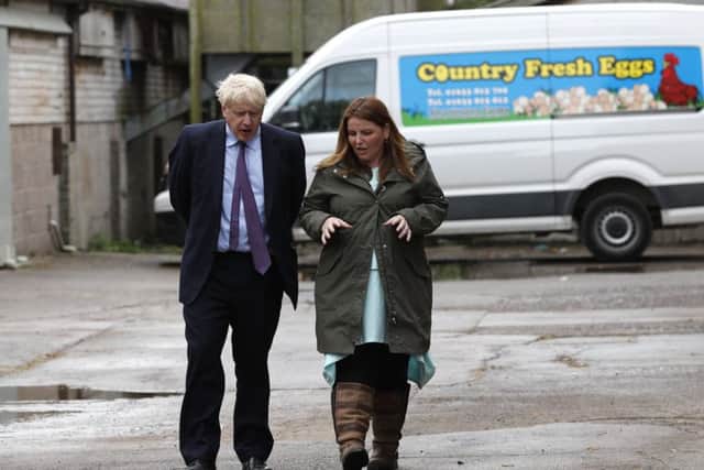 Britain's Prime Minister Boris Johnson, (L), accompanied by local farmer Victoria Shervington-Jones, gestures during his visit to rally support for his farming plans post-Brexit, at Shervington Farm, St Brides Wentlooge near Newport.
