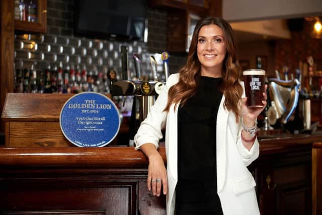 Kym Marsh presenting a personalised blue plaque to publican Georgia at The Golden Lion, commemorating her favourite pub memory, which took place at The Golden Lion in Makerfield, Wigan
